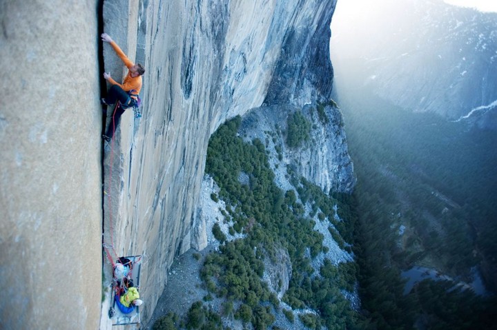 A woman belays on a portaledge while a man climbs on El Cap in Yosemite National Park, California.